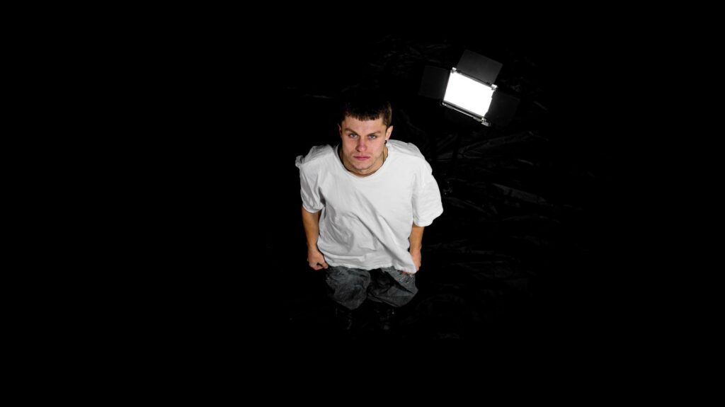 Su sfondo nero Emanuel Boschi vestito di bianco