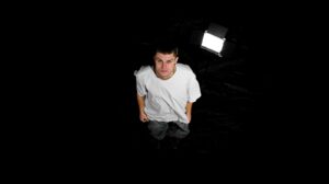 Su sfondo nero Emanuel Boschi vestito di bianco